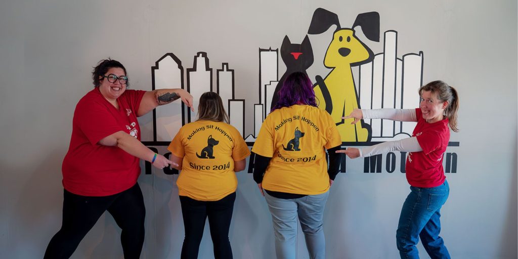Our Approach Paws Around Motown Staff In Front of logo sign